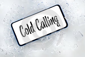 a telephone lying in the ice with the words `cold calling` Pharse, business concept of contacting and establishing cooperation