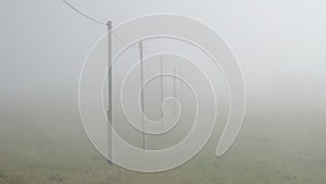 Telephone pole lines vanishing into thick fog Reykjavik Iceland