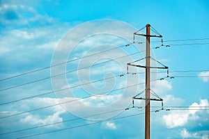 Telephone pole and wires against sky with clouds