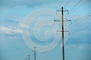 Telephone poles and wires against blue sky