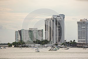 Telephoto shot Miami Beach condominium buildings on the bay with sailboats