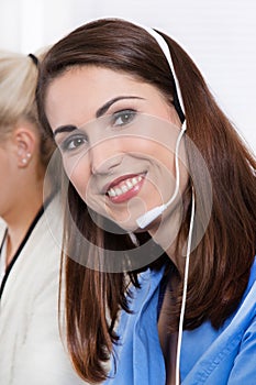 Telesales or helpdesk - happy pretty woman in blue with headset