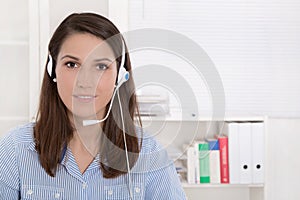 Telesales or helpdesk - helpful woman with headset smiling at ca photo