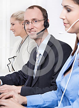 Telesales or helpdesk team - helpful man with headset smiling at