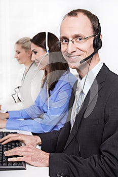 Telesales or helpdesk team - helpful man with headset smiling at