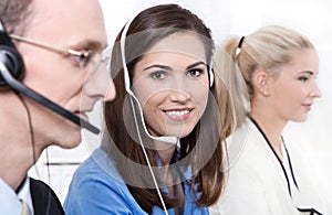 Telesales or helpdesk team - helpful woman with headset smiling photo