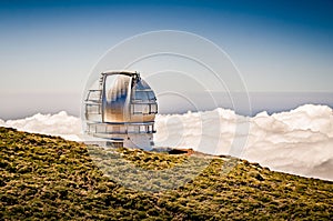 Telescope observatory on a mountain above the clouds. Gran Telescopio Canarias. Telescope dome overlooking the mountain landscape photo