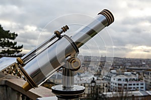 Telescope overlooking Paris. Cloudy sky