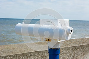 Telescope on seaside promenade.