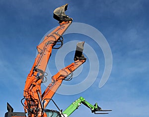 Telescopic handler booms raising in the air with different attachment mounted to the end: two kind of shovels and one forklit