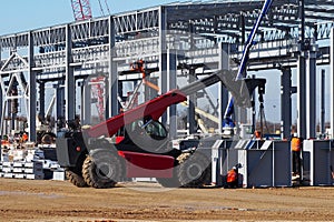 Telescopic handler at work in a large construction site.