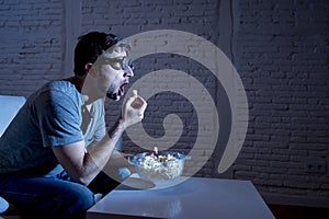 Television addict man on sofa watching TV and eating popcorn in funny nerd geek glasses