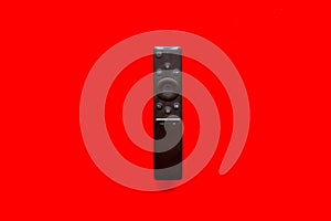 Television air recording concept. TV remote on red background top-down copy space