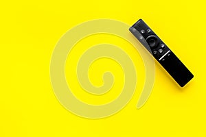 Television air recording concept. TV remote on yellow background top-down copy space