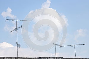 Television antenna on the roof with blue sky and white cloud photo