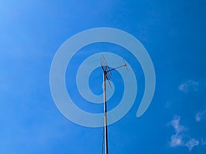 Television antenna standing against blue sky background