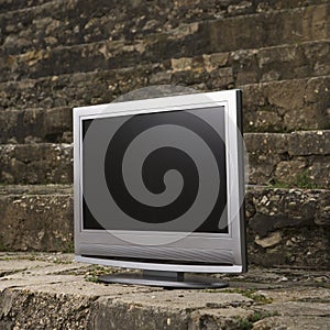 Television by brick wall.