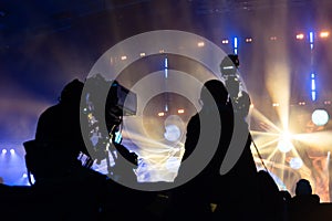 Television broadcast by a cameraman during a concert. Camera with the operator is on the high platform