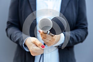 Television journalist holding microphone during media interview