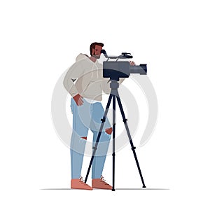 Television operator using video camera on tripod cameraman looking through camcorder movie making concept