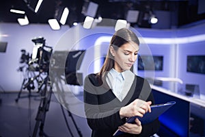 Television presenter recording in news studio.Female journalist anchor presenting business report