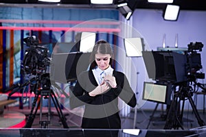 Television presenter recording in news studio.Female journalist anchor presenting business report,recording in television studio