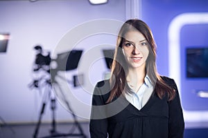 Television presenter recording in news studio.Female journalist anchor presenting business report,recording in television studio photo