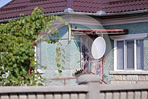 Television satellite receiver antenna on a house in a village in rural Romania