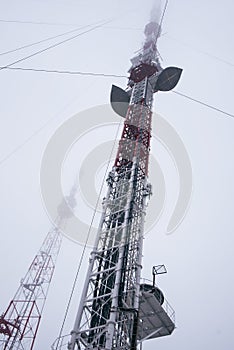 Television tower in the fog on a background cloudy sky