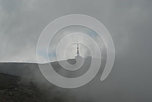 television tower surrounded by clouds and fog