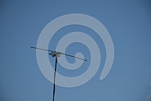 Televisions antennas with clear sky background.