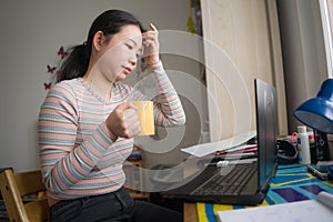 Telework and remote job - lifestyle portrait of young relaxed and beautiful Asian Chinese woman working on laptop at home office