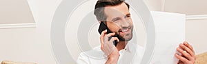 Handsome teleworker smiling while talking on photo