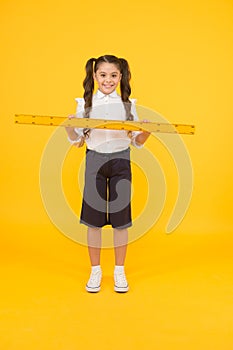 Tell me about distance. Kid school uniform hold ruler. Pupil cute girl with big ruler. Geometry school subject