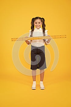 Tell me about distance. Kid school uniform hold ruler. Pupil cute girl with big ruler. Geometry school subject