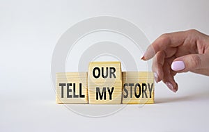 Tell our or my story symbol. Businessman hand points at wooden cubes with words Tell my story and tell our story. Beautiful white