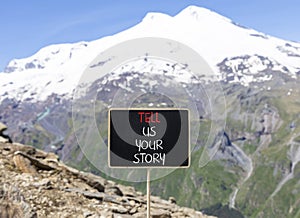 Tell us your story symbol. Concept word Tell us your story on beautiful black chalk blackboard. Beautiful mountain Elbrus