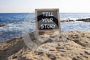 Tell your story symbol. Concept words Tell your story on black chalk blackboard. Beautiful sea background. Business and Tell your