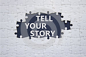 Tell your story symbol. Concept words Tell your story on white puzzle. Beautiful deep blue background. Business and Tell your