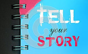 Tell your story words on sky blue page of copyybook in white and pink. Storytelling copywriting concept