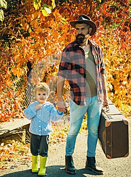 Telling stories about past times. Father with suitcase and his son. Bearded dad telling son about travelling. Traveler