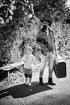 Telling stories about past times. Father with suitcase and his son. Bearded dad telling son about travelling. Traveler