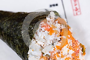 Temaki, nori seaweed cone stuffed with rice, salmon and caviar accompanied by wasabi and gari