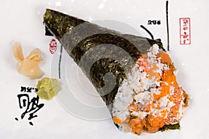 Temaki, nori seaweed cone stuffed with rice, salmon and caviar accompanied by wasabi and gari