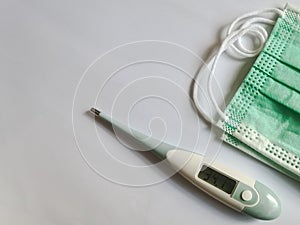 Temperature meter With a sanitary mask on a white background