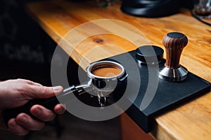 Tempered coffee in portafilter on a dark background