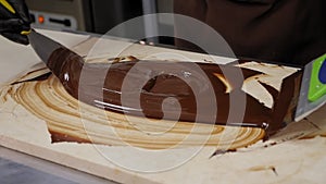 Tempering of the chocolate on the wooden surface.