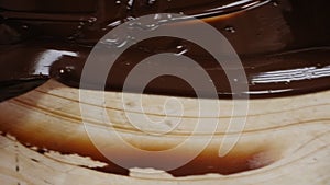 Tempering of the chocolate on the wooden surface.