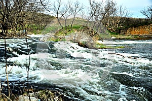 Tempestuous river with small stone rapids