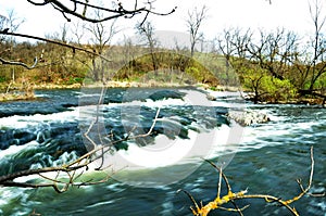 Tempestuous river with small stone rapids photo